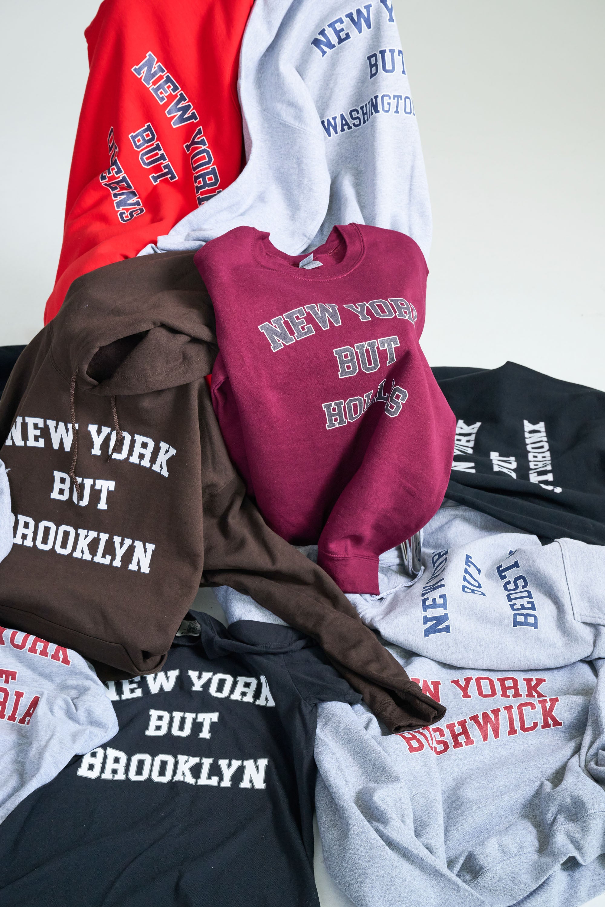 Collection of sweatshirts with 'New York But Brooklyn' text on a white background